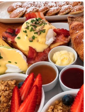 Mesa de brunch com croissants, panquecas e fruta fresca